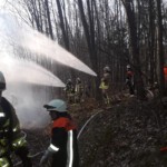 Einsatzkräfte löschen den brennenden Stapel