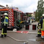 Einsatzkräfte mit Schlauchleitungen vor Anwesen