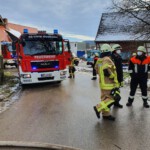 Einsatzkräfte mit Schlauchleitung vor dem Anwesen