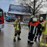 Einsatzkräfte mit Schlauchleitung vor dem Anwesen