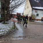 Einsatzkräfte mit Schlauchleitung vor dem Anwesen
