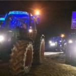 Traktoren auf dem Weg zum Mahnfeuer - Plakat: Ist der Bauer ruiniert, wird klimaschädlich importiert