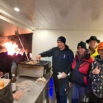 Imbisswager der Feuerwehr mit Bratwürsten auf dem Grill und der grillendesn Jugend